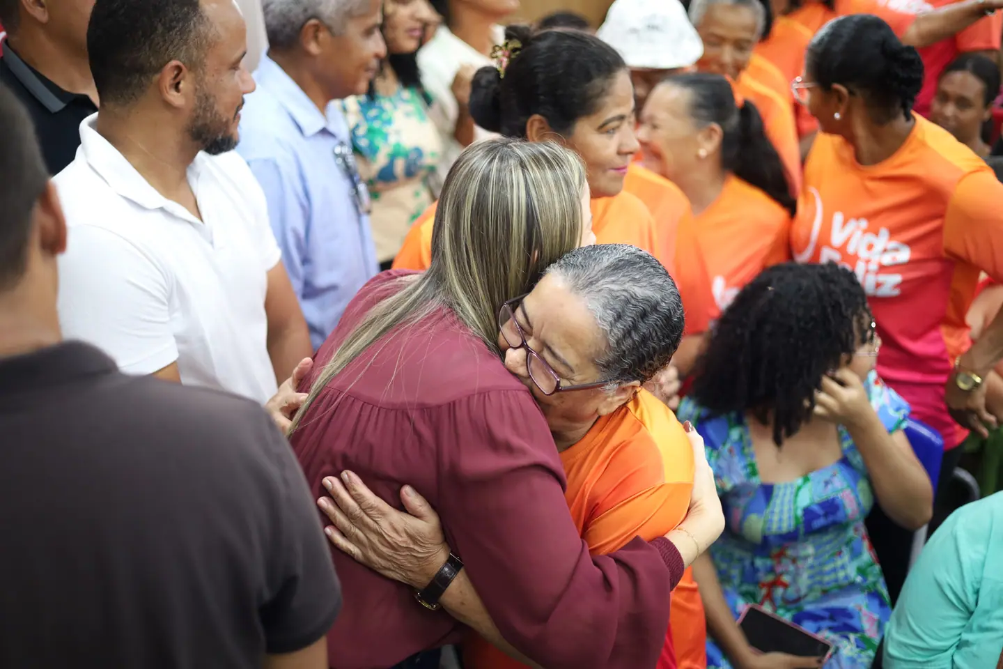 Abraço emocionado entre duas mulheres no meio do público